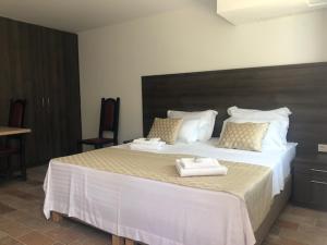 una camera da letto con un grande letto con asciugamani di Luxury Apartments White Villa Violeta a Mandre