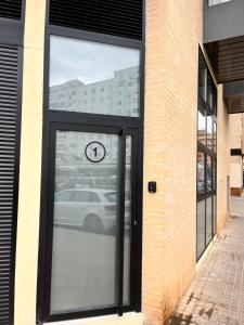 uma porta para um edifício com um carro refletido nele em Loft con carácter en Valencia. em Valência