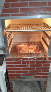 an oven with some food on a rack at Serrado Porteirinha Pedacinho do céu in Porteirinha