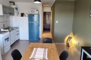 a kitchen with a table and a blue refrigerator at Departamento en pleno Centro de Catriel. in Catriel