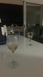dwa kieliszki wina siedzące na stole z oknem w obiekcie Habitaciones vista azul campestre-diagonal a la Foscal w mieście Floridablanca