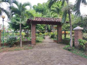 a brick archway in a garden with palm trees at Eco-Lodge El Porvenir. in Santa Cruz +70 photos