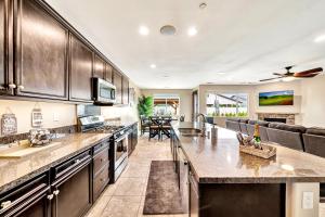 a kitchen with stainless steel appliances and a living room at IndioStay with private Pool, Water Slide, Waterfall, Jacuzzi and Fire Pit near Coachella in Indio