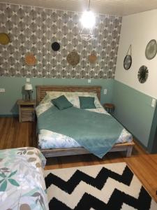 1 dormitorio con 1 cama con edredón verde en Côté Jardin, en Ornans