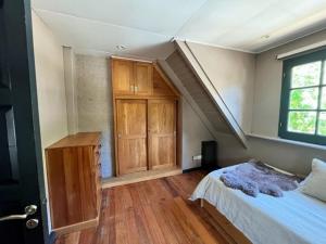 1 dormitorio con 1 cama y armario de madera en Casita de Villegas en San Martín de los Andes
