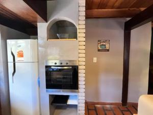 a kitchen with a white refrigerator and an oven at Casita de Villegas in San Martín de los Andes