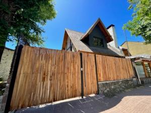 una valla de madera frente a una casa en Casita de Villegas en San Martín de los Andes