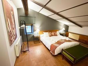 ein Schlafzimmer mit einem großen Bett in einem Zimmer in der Unterkunft Masia de Queralt Luxury Casa Rural Spa y Vistas in Concabella