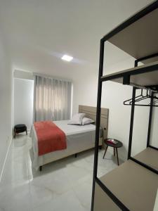 1 dormitorio con cama y espejo en ACHOU! O melhor custo-benefício de Itapema!, en Itapema