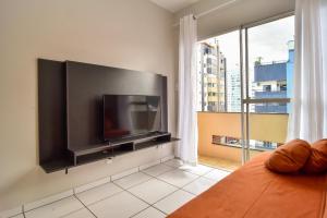 1 dormitorio con TV de pantalla plana grande en la pared en Custo Benefício para 4 hóspedes na Rua 1000 P1947, en Balneário Camboriú