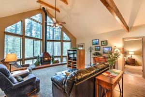 a living room with a leather couch and a television at Prescott Cabin with Beautiful Forest Views and Deck! in Prescott