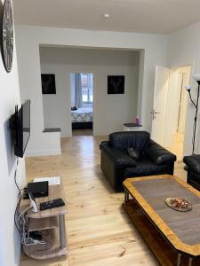 een woonkamer met een zwarte leren bank en een tafel bij Modern Apartment Third Floor in Brussel