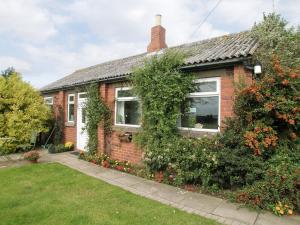 a red brick house with a large window at Searchlight Cottage in Fraisthorpe