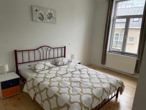 a bedroom with a bed and a large window at Modern Apartment Third Floor in Brussels
