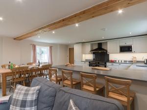 cocina y sala de estar con sofá y mesa en White Lodge Cottage en Carlton Miniott