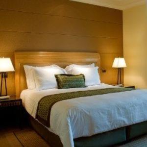 duże łóżko w pokoju hotelowym z 2 lampami w obiekcie Cloud9 Suites w Kitale