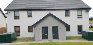 a white house with black doors and windows at Luxurious First Floor Flat in Dornoch