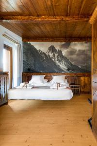 コルティーナ・ダンペッツォにあるホテル エウロパのベッドルーム1室(壁に絵画が描かれたベッド1台付)
