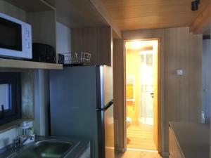 a small kitchen with a refrigerator and a microwave at HUEPIL, Monoambiente Centrico in San Martín de los Andes +50 photos