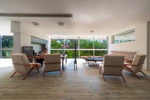 uma sala de estar com cadeiras, uma mesa e janelas em Hotel Balcón del Parque em Xalapa