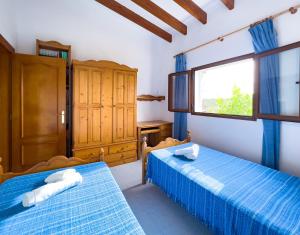 1 dormitorio con 2 camas y ventana en Can Pep Yern 1, en Playa de Migjorn