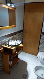 a bathroom with a sink and a toilet at Cabañas la Delfina in Potrero de los Funes