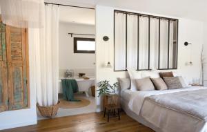 um quarto com uma cama e uma casa de banho com uma banheira em La Grange de Fer I Classée 5 étoiles em Saint-Ferréol-Trente-Pas