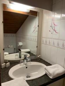 W łazience znajduje się umywalka i lustro. w obiekcie Hotel Le Concorde w mieście Morzine