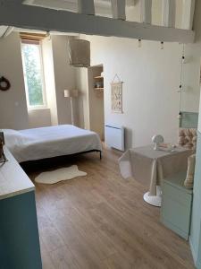ein Schlafzimmer mit einem Bett und einem Tisch darin in der Unterkunft Studio du Grand Beaumont in Saint-Mélaine-sur-Aubance