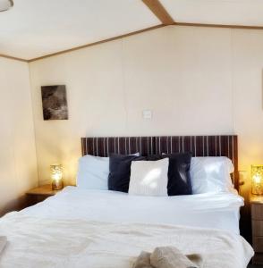 - une chambre avec un lit doté de draps blancs et d'oreillers bleus dans l'établissement 31 solent village, à Porchfield