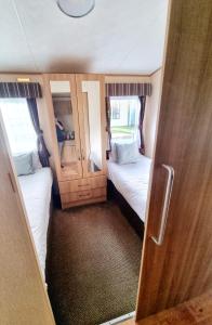 Habitación pequeña con 2 camas y puerta de madera en 31 solent village en Porchfield