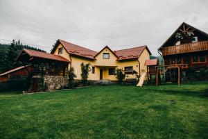 une grande maison avec une cour en face dans l'établissement Casa Roland, à Gheorgheni