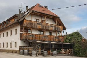 a large wooden building with a balcony at Guesthouse Novak in Dvor