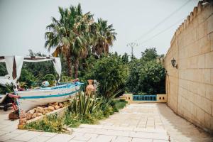een boot in een tuin naast een muur bij DAR BELDI in Hammamet