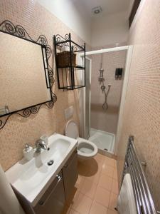 a bathroom with a sink and a toilet and a mirror at B&B La Piazzetta della Pioggia in Bologna