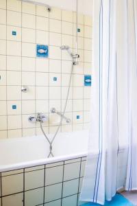 uma casa de banho com um chuveiro e uma banheira com uma cortina de chuveiro em Celler Appartement em Celle