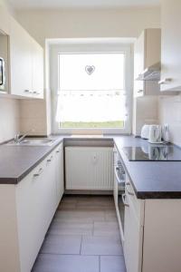 una cucina bianca con finestra e lavandino di Celler Appartement a Celle