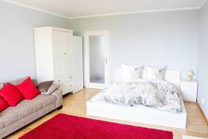 una camera bianca con un letto e un divano di Celler Appartement a Celle