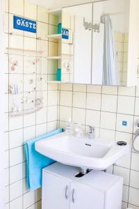 bagno bianco con lavandino e specchio di Celler Appartement a Celle