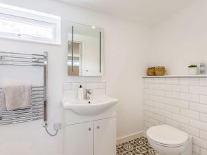 uma casa de banho branca com um lavatório e um WC em Kingsleys Lodge em Barnstaple