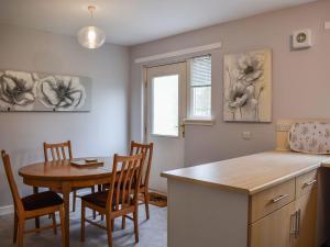 uma cozinha e sala de jantar com mesa e cadeiras em Beechwood em Arrochar