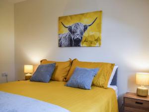 sypialnia z łóżkiem z obrazem krowy w obiekcie Beechwood w mieście Arrochar