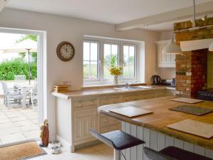 a kitchen with a counter and a clock on the wall at Walnut Tree House in Terrington Saint John