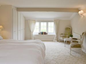 a white bedroom with a bed and a window at Walnut Tree House in Terrington Saint John