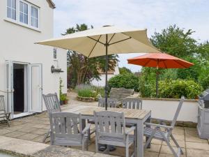 - une table et des chaises avec un parasol sur la terrasse dans l'établissement Walnut Tree House, à Terrington Saint John