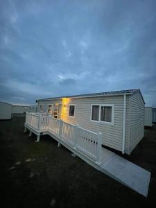 a mobile home with a porch and a deck at Lexi Lodge @ Littlesea Holiday Park, Weymouth in Wyke Regis