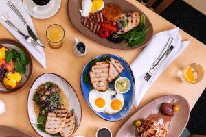 een tafel met borden ontbijtproducten erop bij Arawa Park Hotel, Independent Collection by EVT in Rotorua