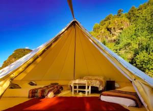 a tent with two beds and a table in it at Amanecer Glamping in llifen