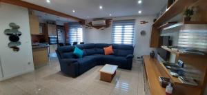 sala de estar con sofá azul y cocina en Apartamento Txoko Txikia, en Echarri-Aranaz