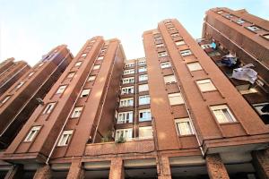 un edificio alto de ladrillo rojo con ventanas en Precioso apartamento en Los Castros, en Santander